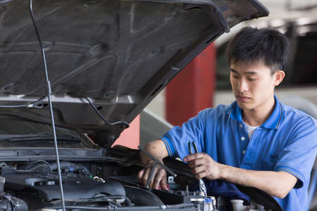 Bangkok, Thailand - January 21 : automobile mechanic examining car suspension of lifted  automobile at at Mitsubishi Motor Service station on January 21, 2015. Bangkok, Thailand.のeditorial素材