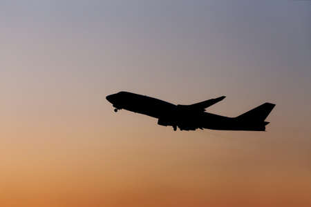 Silhouette airplane in the sunset skyの写真素材