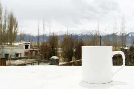 white coffee cup with Himalaya mountain view at Ladakh, Indiaの写真素材
