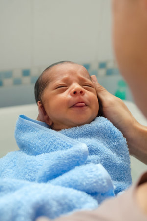 asian father holding and bathing newborn for the first time of life in the morning. baby laughing...