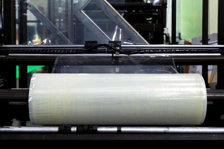 roll of plastic packaging film on the automatic packing machine in food product factory. industrial and technology concept.の写真素材