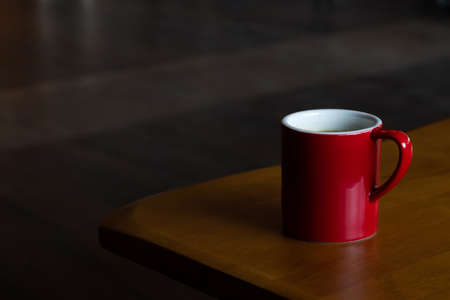 mug of hot americano black coffee on the top of the wooden table with morning light at the coffee shop. coffee break for refreshing in the working time.の写真素材