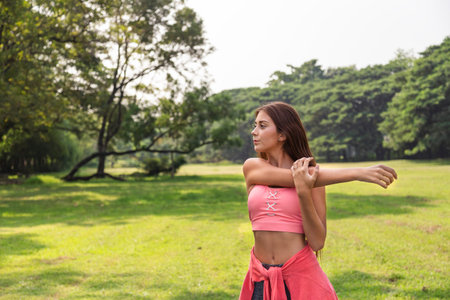 healthy young teenage girl stretching arms workout and warmup before fitness training session in the...