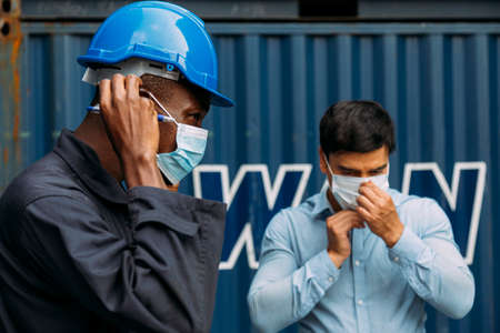 african worker and businessman wearing face mask to protect covid or coronavirus pandemic and pm2.5 bad air pollution from traffic and manufacturing industrials.の写真素材