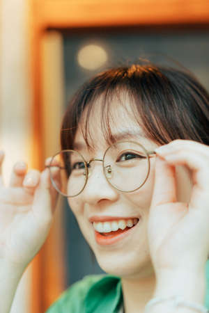 A cheerful girl with her glasses.の写真素材
