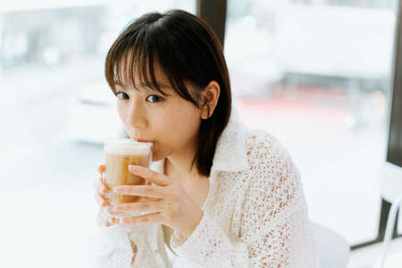 A girl eating happily in a cafe.の写真素材