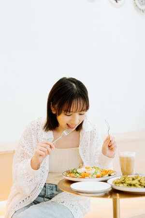 A girl eating happily in a cafの写真素材