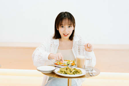A girl eating happily in a cafの写真素材