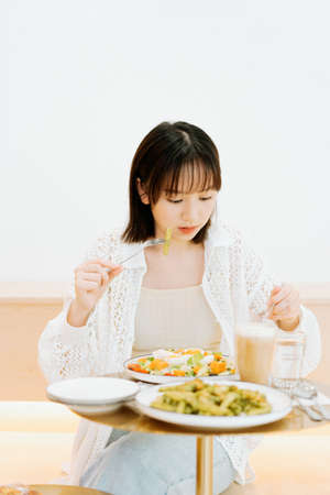 A girl eating happily in a cafの写真素材