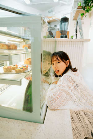 asian young girl exploring in a cafe.の写真素材