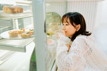 asian young girl exploring in a cafe.の写真素材