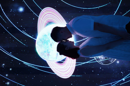 Young couple hugging each other against planet earth hologram against black background