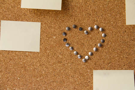 Office board with note papers and heart made from pinsの写真素材