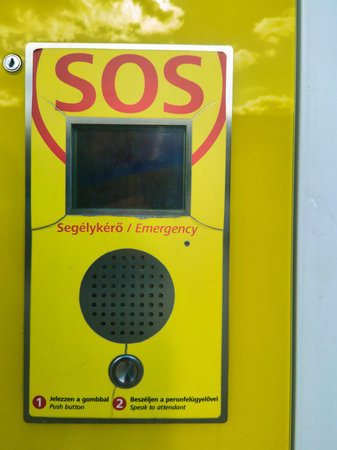 A vibrant yellow emergency SOS call box found in public transit areas. Features a screen, speaker,...