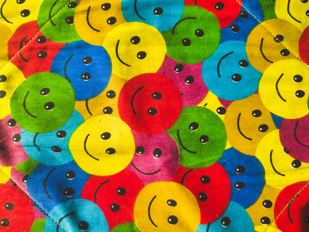 A high-quality top-down shot of quilted fabric featuring repetitive yellow, red, blue, and green...