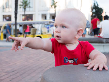 Young mother with her toddler son playing outdoors in city.の写真素材