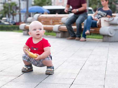 Young mother with her toddler son playing outdoors in city.の写真素材