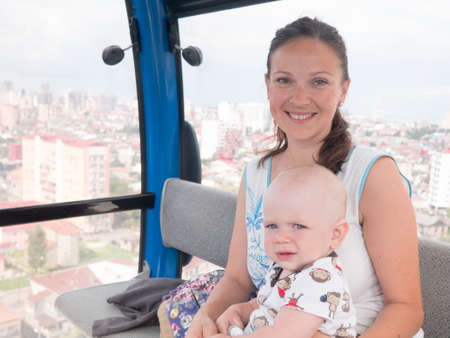 Cute baby and mother rise to the cable car to mountain.の写真素材