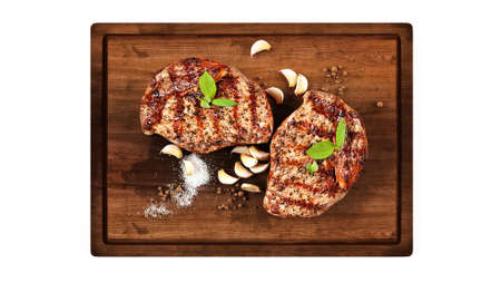 Raw beef filet steak on a wooden Board with garlic, pepper, and salt.の写真素材