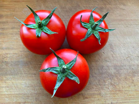 Branch of three fresh red tomatoes.の写真素材