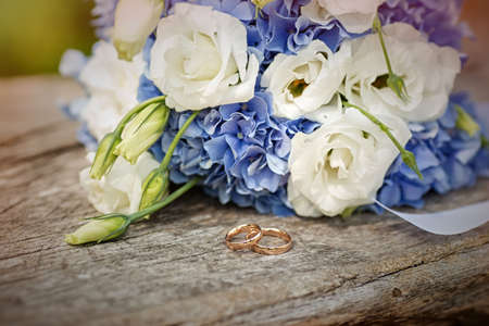 White and blue wedding bouquet with wedding rings on an old tree. High quality photoの写真素材