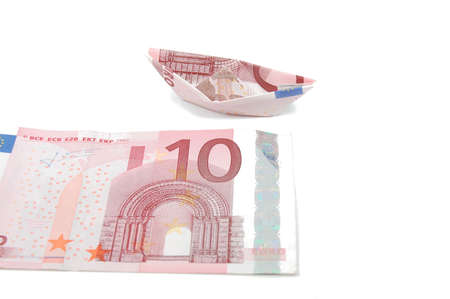 Money and a Ship Isolated on white background.Geld und ein Papierschiffchen auf weiÃem Grund.の写真素材