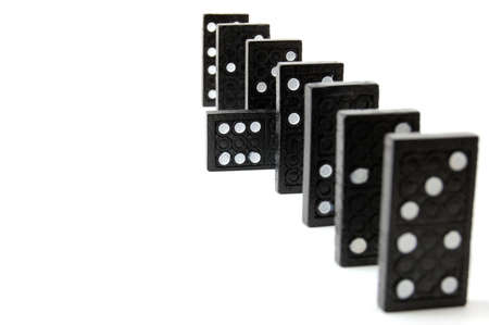 row of dominoes including a special domino stone isolated on white backgroundの写真素材
