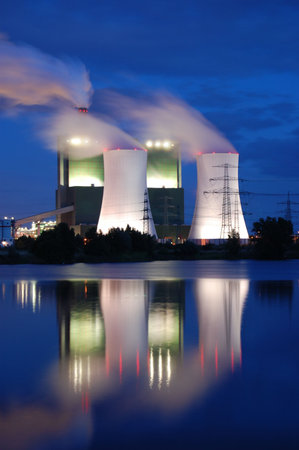 a smoking industrial power plant at nightの写真素材