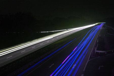 road with car traffic at night and blurry lights showing speed and motionの写真素材