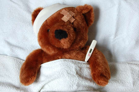 sick teddy bear with injury in a bed in the hospitalの写真素材
