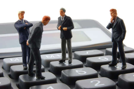 toy business man on calculator isolated on white backgroundの写真素材