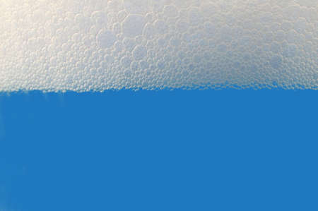 colored drink with foam isolated on white backgroundの写真素材