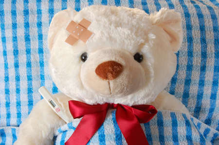 ill teddy bear in bed waiting for medicineの写真素材