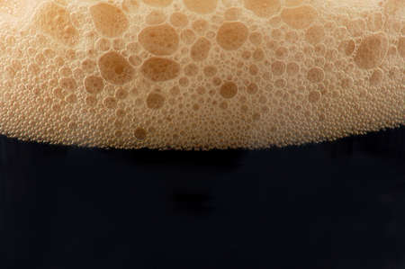 dark beer isolated on white background with foamの写真素材