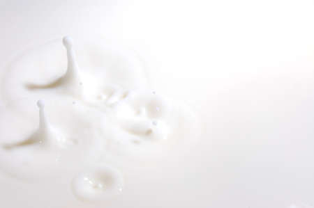 drop of milk splashes into fresh milkの写真素材