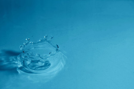 fresh water drop splashing in blue cool water