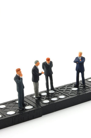 businessman standing on domino stones isolated on white backgroundの写真素材