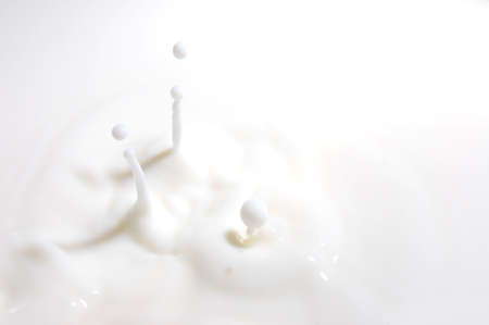 drop of milk splashes into fresh milkの写真素材