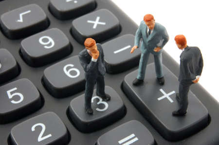 toy business man on calculator isolated on white backgroundの写真素材