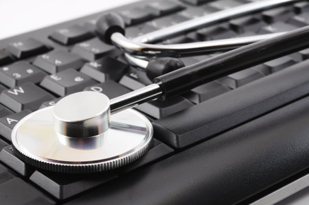 stethoscope on keyboard showing computer problem conceptの写真素材