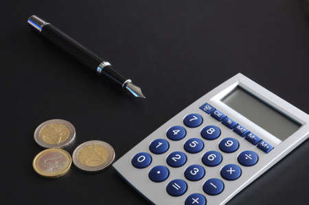 save money concept with calculator and euro money coins on blackの写真素材