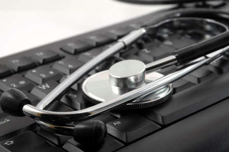 stethoscope on keyboard showing computer problem conceptの写真素材