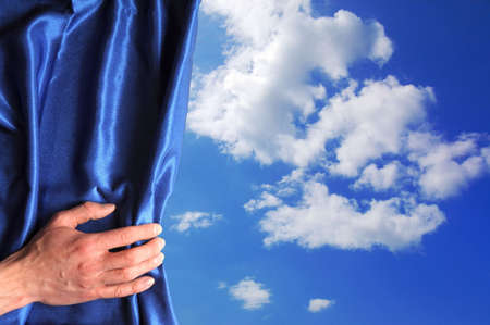 blue sky behind curtain and hand with copyspace fpr text messageの写真素材