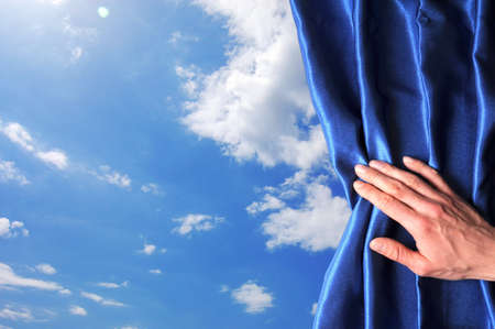 blue sky behind curtain and hand with copyspace fpr text messageの写真素材