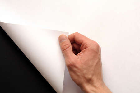 hand turning over blank sheet of paperの写真素材