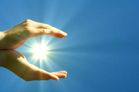 hand sun and blue sky with copyspace showing freedom or solar power conceptの写真素材