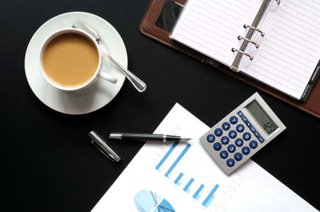 coffee pen phone and paper on desk in officeの写真素材