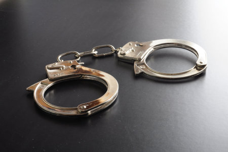 police handcuffs on black background showing law conceptの写真素材