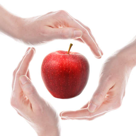 hand and apple isolated on a white background showing healthy food conceptの写真素材