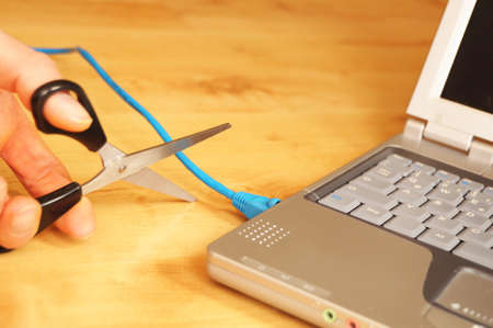 wireless lan or internet connection concept with laptop cable and scissorsの写真素材